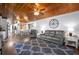 Cozy living room with wood ceiling, comfortable seating, and view into kitchen and dining area at 3299 County Road 521, Wildwood, FL 34785