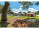 Expansive backyard showcasing a screened-in pool, lush lawn, mature trees, and ample space for outdoor activities at 3881 Se 61St Pl, Ocala, FL 34480