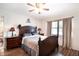 Charming bedroom with dark wood furnishings, a ceiling fan, and a window with curtains at 3881 Se 61St Pl, Ocala, FL 34480