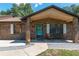 Close up of the front door and porch with chairs and a flower wreath at 3881 Se 61St Pl, Ocala, FL 34480