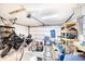 Cluttered garage featuring a motorcycle, bicycle and storage shelves at 3881 Se 61St Pl, Ocala, FL 34480