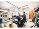 A well-lit garage filled with tools, shelving, and motorcycle at 3881 Se 61St Pl, Ocala, FL 34480