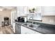 Bright kitchen with white cabinets, stainless steel appliances, and dark countertops at 3881 Se 61St Pl, Ocala, FL 34480