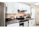 Kitchen with stainless steel appliances, dark countertops, and white cabinets at 3881 Se 61St Pl, Ocala, FL 34480