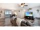 Open living room space with dining room, gray sofa, hard surface floors and flat screen TV at 3881 Se 61St Pl, Ocala, FL 34480