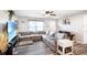 Inviting living room features gray wood floors, large sectional couch, ceiling fan, and decor at 3881 Se 61St Pl, Ocala, FL 34480