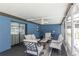 Relaxing screened patio with stylish furniture, a ceiling fan, and bright blue walls at 3881 Se 61St Pl, Ocala, FL 34480