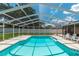 Inviting pool area with a screened enclosure, surrounded by a sunny patio and lush backyard at 3881 Se 61St Pl, Ocala, FL 34480