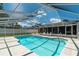 Enjoy this screened-in pool with blue water, white patio furniture, and a relaxing outdoor space at 3881 Se 61St Pl, Ocala, FL 34480