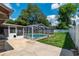 Outdoor view of a screened in pool with a well maintained concrete deck and backyard at 3881 Se 61St Pl, Ocala, FL 34480