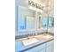 Bright bathroom featuring double sinks, white cabinetry, and decorative mirrors at 5009 Neptune Cir, Oxford, FL 34484