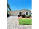 Charming single-story home featuring a paver driveway and well-maintained landscaping at 5009 Neptune Cir, Oxford, FL 34484