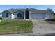Charming single-story home with manicured lawn, inviting entryway, attached two car garage, and a long driveway at 5391 Nw 19Th Pl, Ocala, FL 34482