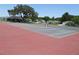 View of community tennis courts with trees and homes in the background at 5391 Nw 19Th Pl, Ocala, FL 34482