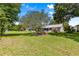 The backyard is a spacious green lawn with mature trees adding to its beauty at 8532 Sw 65Th Court Rd, Ocala, FL 34476