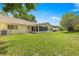 Spacious backyard featuring a well-manicured lawn, mature trees, and a screened-in patio at 8710 Sw 91St St # E, Ocala, FL 34481