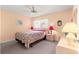 Bedroom with a ceiling fan, large window and a comfortable bed with floral bedding at 8710 Sw 91St St # E, Ocala, FL 34481