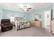 Comfortable bedroom features a ceiling fan, floral bedding, dresser and a door leading to the bathroom at 8710 Sw 91St St # E, Ocala, FL 34481