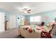 Bedroom featuring a ceiling fan, floral bedding, dresser and door to the bathroom at 8710 Sw 91St St # E, Ocala, FL 34481