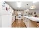 Open kitchen with hanging pendant lights, wood floors, and island with breakfast bar at 8710 Sw 91St St # E, Ocala, FL 34481