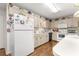 Bright kitchen features white appliances, wood floors, and upper cabinet display shelf at 8710 Sw 91St St # E, Ocala, FL 34481