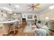 Spacious living room is open to kitchen featuring wood floors, breakfast bar and ceiling fan at 8710 Sw 91St St # E, Ocala, FL 34481