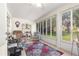 Sunroom featuring large windows that provide abundant natural light, a ceiling fan, and tile floors at 8710 Sw 91St St # E, Ocala, FL 34481