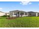 Backyard featuring green lawn, screened lanai, and new landscaping at 8816 Sw 69Th Place Rd, Ocala, FL 34481