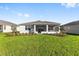 The backyard features lush green lawn, screened lanai, and professionally landscaped yard at 8816 Sw 69Th Place Rd, Ocala, FL 34481