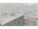 Bright bathroom with gray cabinets, modern fixtures, and shower-tub combo at 8816 Sw 69Th Place Rd, Ocala, FL 34481