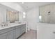 Bathroom with dual sinks, gray cabinets, and frameless glass shower enclosure at 8816 Sw 69Th Place Rd, Ocala, FL 34481