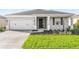 Charming home shows a two-car garage, welcoming entrance, manicured lawn, and neat landscaping at 8816 Sw 69Th Place Rd, Ocala, FL 34481