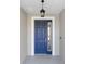 A close-up of the attractive six-paneled blue front door with sidelight and an overhead lantern at 8816 Sw 69Th Place Rd, Ocala, FL 34481