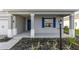 Charming front porch featuring a blue front door, blue shutters, and a landscaped garden bed at 8816 Sw 69Th Place Rd, Ocala, FL 34481