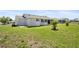 Rear exterior with a screened-in porch and a spacious grassy backyard at 8849 Sw 116Th Place Rd, Ocala, FL 34481