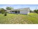 View of the rear exterior featuring siding, screens and a well maintained lawn at 8849 Sw 116Th Place Rd, Ocala, FL 34481