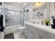 Bright bathroom with white shiplap walls, gray vanity, and a shower-tub combination at 8849 Sw 116Th Place Rd, Ocala, FL 34481