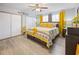 Bright bedroom features a ceiling fan, light-colored floors, and sunny yellow accents at 8849 Sw 116Th Place Rd, Ocala, FL 34481