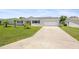 Charming single-story home with a well-manicured lawn, long driveway, and attached two-car garage at 8849 Sw 116Th Place Rd, Ocala, FL 34481