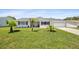 Charming home featuring a well-maintained lawn, an attached two-car garage, and beautiful landscaping with lovely palm trees at 8849 Sw 116Th Place Rd, Ocala, FL 34481