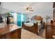 Spacious bedroom features hardwood furniture, a ceiling fan, and bright curtains at 8849 Sw 116Th Place Rd, Ocala, FL 34481