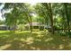 Large backyard with mature trees, screened-in porch, and an open grassy area at 8926 Sw 192Nd Court Rd, Dunnellon, FL 34432