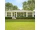 Lush green lawn with clipped hedges, screened lanai, and backyard landscape views at 8926 Sw 192Nd Court Rd, Dunnellon, FL 34432