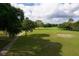 Scenic golf course view with lush green grass, mature trees, and blue skies with fluffy clouds at 8926 Sw 192Nd Court Rd, Dunnellon, FL 34432