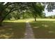 Lush golf course view featuring mature trees and a walking path, perfect for enjoying the outdoors at 8926 Sw 192Nd Court Rd, Dunnellon, FL 34432