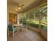 Screened lanai with furniture overlooking a garden and wooded area at 8926 Sw 192Nd Court Rd, Dunnellon, FL 34432