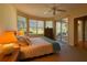 Bright main bedroom with a ceiling fan, large windows and sliding door access to the patio at 8926 Sw 192Nd Court Rd, Dunnellon, FL 34432