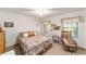 Cozy bedroom with a floral bedspread, natural light and a rocking chair at 8940 Sw 8Th St, Ocala, FL 34481