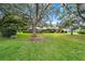 Mature trees surrounding a single-story home with lush grass, offering privacy and shade at 8940 Sw 8Th St, Ocala, FL 34481