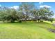 Lush front yard with mature oak trees and an expansive lawn area, showing the scale of the property at 8940 Sw 8Th St, Ocala, FL 34481